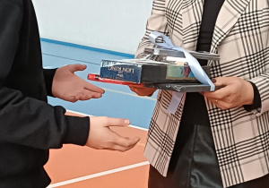 Dyrektor wręcza nagrodę uczniowi