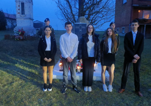 Uczniowie przed pomnikiem poległych w czasie II wojny światowej w Bujnach