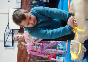 Uczeń wykonujący uciśnięcia klatki piersiowej na fantomie