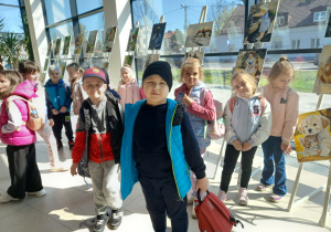 Uczniowie w holu Mediateki przed galerią prac