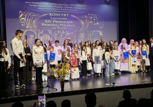 Laureaci przeglądu z prowadzącymi i organizatorami na scenie