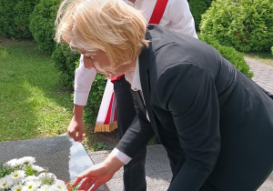 Delegacja składająca z Panią Dyrektor kwiaty pod pomnikiem