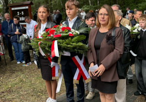 Delegacja szkoły składająca wiązankę pod pomnikiem