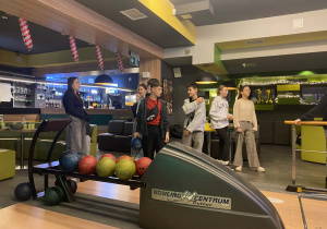 Grupa uczniów przy stanowisku do gry w kręgle