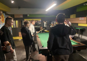 Grupa uczniów przy stole bilardowym
